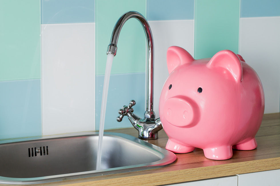 Picture contains a photograph of a piggybank next to a running tap
